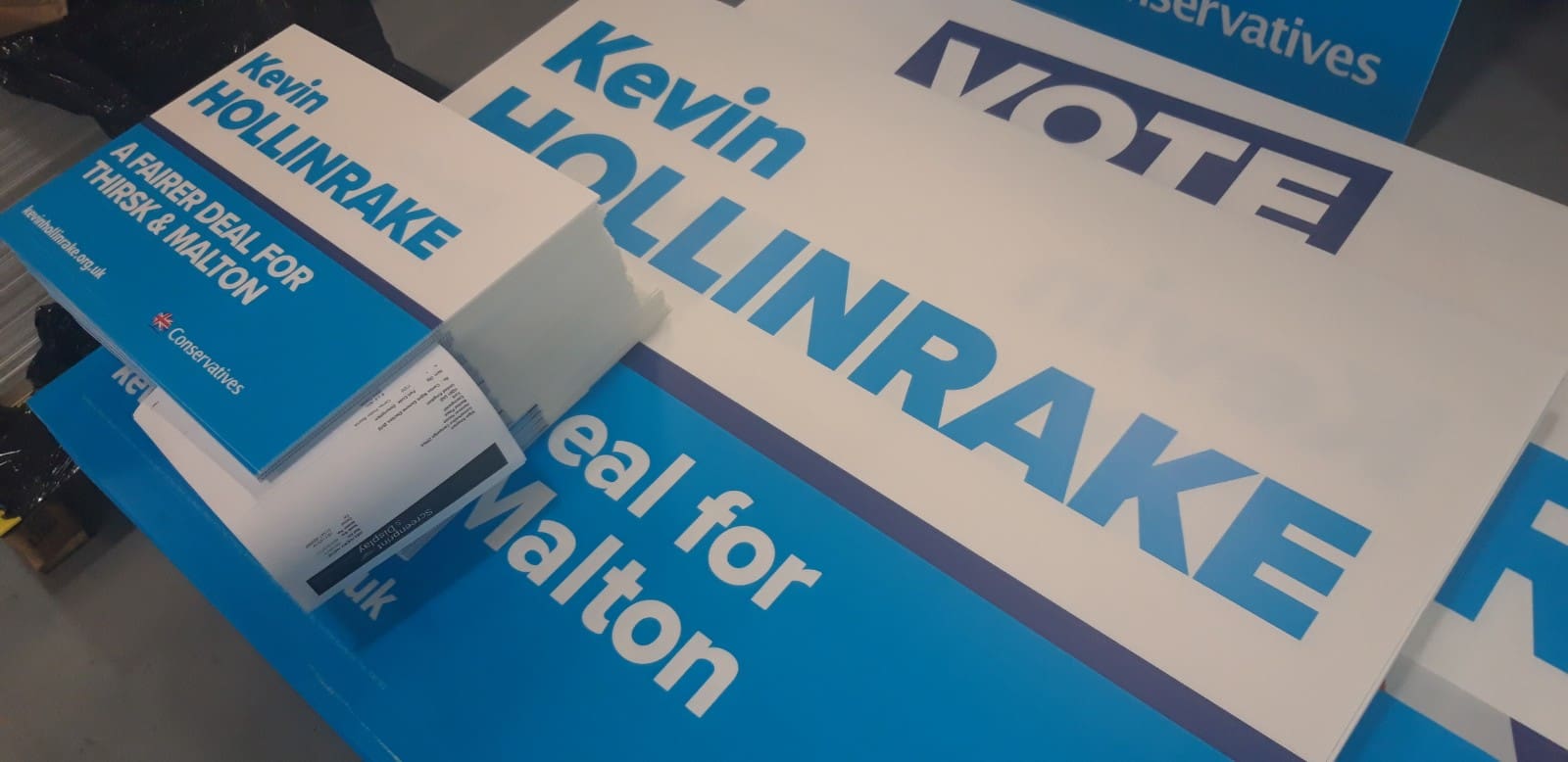 How do political candidates use election signs and other campaign materials to influence voters